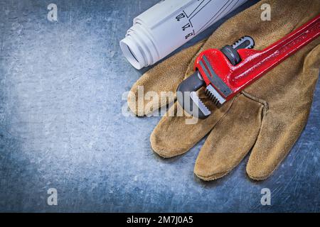 Gants de protection pour clé à pipe Blueprints sur fond métallique concept de plomberie. Banque D'Images