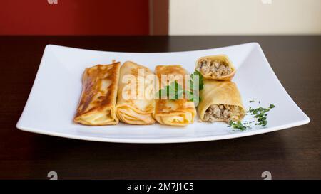 Un blini, ou parfois blin, est une crêpe russe et plus largement européenne de l'est qui est traditionnellement faite à partir de sarrasin ou de farine de blé. Banque D'Images