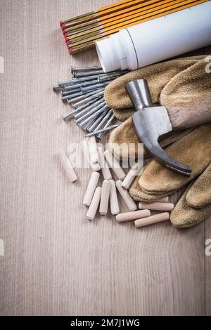 Les goujons de mesure en bois Blueprints une paire de gants de sécurité et des clous métalliques pour la construction de panneaux de bois. Banque D'Images