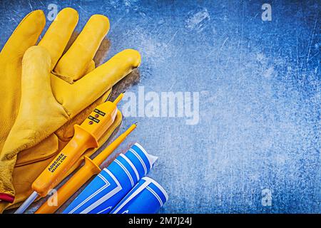 Gants de sécurité jaune pour testeur électrique bleus sur fond métallique. Banque D'Images