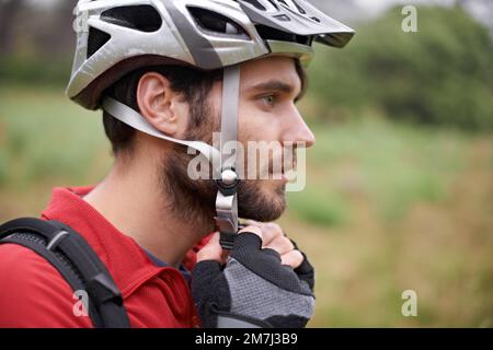 S'assurer que les hes sont protégés. Un jeune cycliste qui attache son casque. Banque D'Images