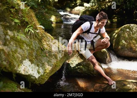 Profiter de la paix et de la tranquillité de la forêt. un beau jeune homme qui fait de la randonnée dans la forêt. Banque D'Images