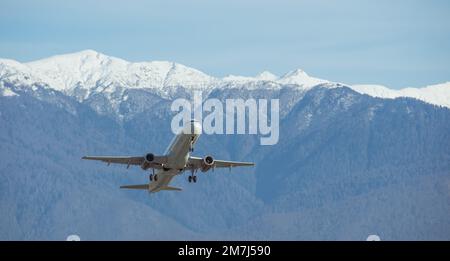 Les avions civils de passagers se délatent sur fond de montagnes enneigées Banque D'Images