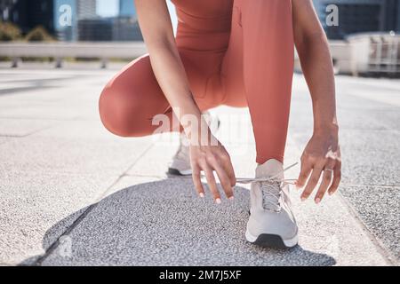 Mains, fitness et femme noire cravate chaussures se préparer pour l'entraînement en ville. Entraînement, athlète sportif et coureur nouant la dentelle de la sneaker et Banque D'Images