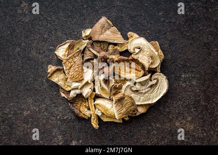 Les champignons séchés tranchés sur table noire. Vue de dessus. Banque D'Images