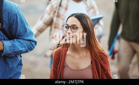 Une femme heureuse, des étudiants et des promenades à l'université, sur le campus ou à l'école dans le trajet matinal en classe, pause d'étude ou repos. Sourire, personnes ou liens Banque D'Images