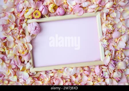 Pétales de rose, bourgeons de rose avec cadre en bois vide. Flat lay, espace de copie. Fête des mères, St. Saint-Valentin, concept 8 mars. Vue de dessus, plat la Banque D'Images