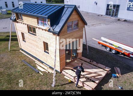 PRODUCTION - 19 septembre 2022, Mecklembourg-Poméranie occidentale, Brüsewitz: Tom Hinze et Stefan Kröplin construisent une première petite maison modèle (vue aérienne avec un drone). Il a été construit et fabriqué dans un magasin de menuiserie à Upahl depuis mars 2022. La maison de construction écologique a une façade de mélèze sibérien et des fenêtres faites à la main en bois de chêne. La maison, qui mesure 3,30 mètres de large et sept mètres de long, a une hauteur de crête de cinq mètres et offre 30 mètres carrés d'espace de vie sur deux étages. S'il y a suffisamment d'intérêt pour le client, jusqu'à dix maisons par an doivent être fabriquées dans le craf Banque D'Images