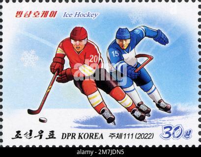 Timbre-poste nord-coréen de 2022 représentant deux joueurs de hockey sur glace en action, dans le cadre d'une série de sports d'hiver. Banque D'Images