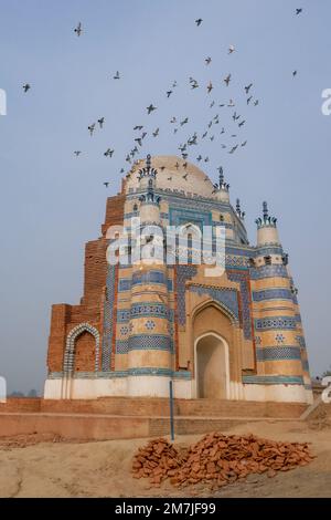 Vue sur le paysage de l'architecture médiévale de l'ancien tombeau bleu octogonal de Bibi Jawindi avec des pigeons volants, UCH Sharif, Bahawalpur, Punjab, Pakistan Banque D'Images