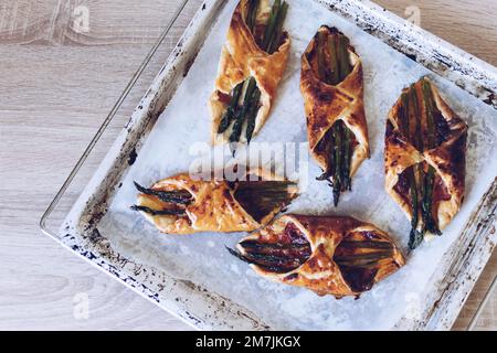 Asperges cuites dans une pâte feuilletée avec jambon et fromage Banque D'Images