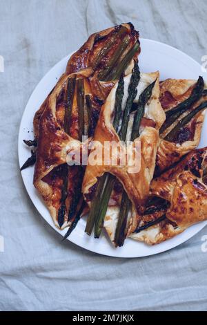 Asperges cuites dans une pâte feuilletée avec jambon et fromage Banque D'Images