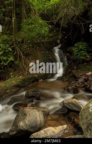 Un cliché vertical d'une petite cascade au-dessus d'une rivière rocheuse Banque D'Images