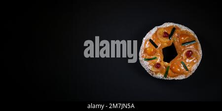 Style sud-français Gâteau des Rois aux fruits confits, gâteau Epiphanie, avec fond noir et espace de copie pour le texte ou les titres Banque D'Images