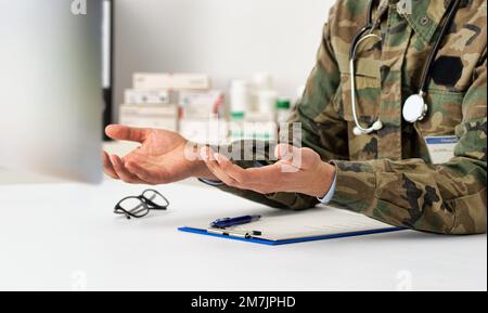 Plan rogné d'un médecin de l'armée parlant la vidéo conférence sur ordinateur à l'aide de l'application de consultation en ligne d'appel vidéo. Aide médicale à distance pour les patients à distance Banque D'Images