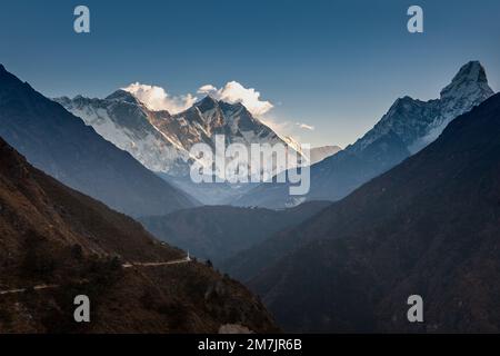 Vue sur la colline avec sentier de montagne et montagnes enneigées en arrière-plan. Vue sur le lever du soleil de AMA Dablam et Lhotse. Magnifique paysage de sentier de montagne. Banque D'Images