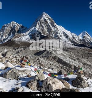 Drapeaux de prière bouddhistes sur la montagne cairns sur la route du camp de base de l'Everest dans l'Himalaya, Népal. Banque D'Images
