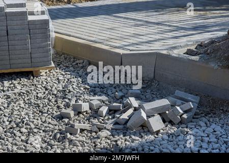 Préparation pour la pose de briques de béton gris sur les pavés d'aménagement paysager de chaussées pendant la construction de trottoirs Banque D'Images