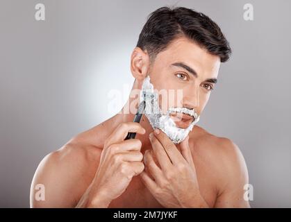 Toilettage, mousse et rasage avec visage d'homme avec rasoir pour la beauté, l'hygiène et les soins de la peau avec routine du matin. Soin de soi, soin du visage et rasage de la barbe avec Banque D'Images