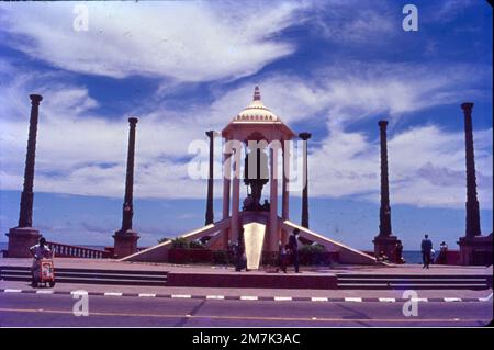 Une structure blanche entourée de piliers de granit abrite une statue en bronze du chef de l'indépendance. La statue du Mahatma Gandhi à Pondichéry est un hommage au père de Nation, placé en l'an 1965 à Promenade Beach. Il est entouré de huit piliers de granit monolithique finement sculptés qui ont été apportés du fort de Gingee. La statue mesure 4 m (13 pieds) de haut Banque D'Images