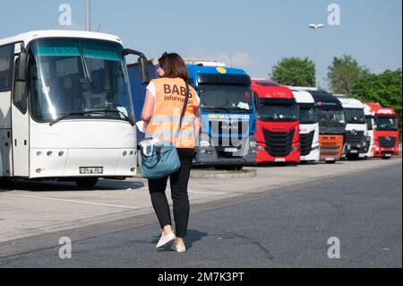 18 mai 2022, Saxe, Dresde: Paulina Bukaiova, employée du Service consultatif pour les employés étrangers en Saxe (BABS), marche devant les camions stationnés dans la zone de service de l'autoroute Dresdner Tor. Le centre de conseil fournit des informations aux employés étrangers travaillant en Saxe au nom du ministère du travail de Saxe. Photo: Sebastian Kahnert/dpa Banque D'Images