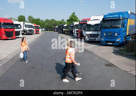 18 mai 2022, Saxe, Dresde: Paulina Bukaiova (r) et Ünige Albert, employés du Service consultatif pour les employés étrangers en Saxe (BABS), marchent devant les camions stationnés dans la zone de service de l'autoroute Dresdner Tor. Le centre de conseil fournit des informations aux employés étrangers travaillant en Saxe au nom du ministère du travail de Saxe. Photo: Sebastian Kahnert/dpa Banque D'Images