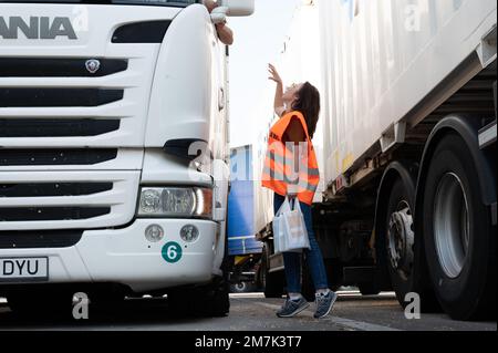 18 mai 2022, Saxe, Dresde: Ünige Albert, employé du Service consultatif pour les employés étrangers en Saxe (BABS), parle à un chauffeur de camion à la station de service d'autoroute Dresdner Tor. Le centre de conseil fournit des informations aux employés étrangers travaillant en Saxe au nom du ministère du travail de Saxe. Photo: Sebastian Kahnert/dpa Banque D'Images