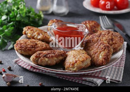 Côtelettes de filet de dinde et de flocons d'avoine, frites dans une poêle, servies avec une sauce tomate, gros plan Banque D'Images