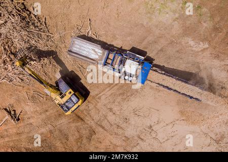 Préparer le terrain pour le développement du logement Grande machine de déchiquetage industrielle utilisée pour déchiqueter les racines en copeaux dans l'ordre de nettoyage du territoire Banque D'Images