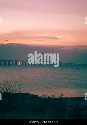 Un cliché vertical du magnifique pont d'Oresund au-dessus de la mer avec le coucher de soleil rose en arrière-plan Banque D'Images