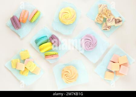 Divers bonbons : macarons, guimauves et zéphans. Desserts traditionnels colorés pour les vacances. Vue de dessus. Banque D'Images