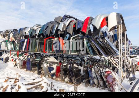 Les voitures démontées sur un dépotoir sont en vente pour les pièces de rechange. Une pile de portes et de pare-chocs. Le commerce des pièces de rechange d'occasion est une activité commune dans le développement Banque D'Images