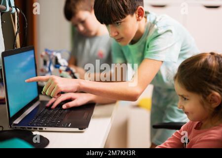 Les enfants apprennent à réparer le bras robot de commande de leçon, le bras de machine robotique dans l'atelier à domicile, la technologie future éducation scientifique. Banque D'Images