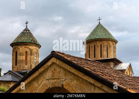 Tours du monastère des gelati, complexe monastique médiéval près de Kutaisi, Géorgie fondée par le roi David IV, église orthodoxe en pierre avec toit de tuiles vertes. Banque D'Images