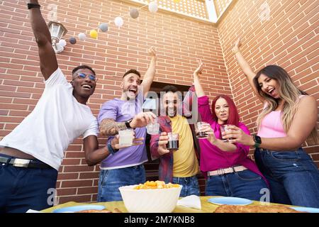 Des amis enthousiastes qui célèbrent et s'amusent tout en faisant une fête à l'extérieur. Concept d'amitié. Banque D'Images