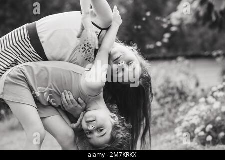 Noir et blanc Portrait de deux jolies petites filles qui embrassent et rient au jardin. Des enfants heureux à l'extérieur Banque D'Images