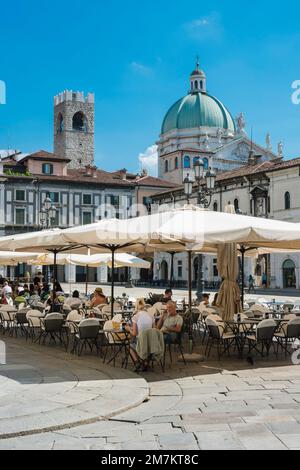 Italie piazza bar, vue d'été des personnes se détendant aux tables de l'époque de la Renaissance Piazza della Loggia dans le centre historique de Brescia, Italie Banque D'Images