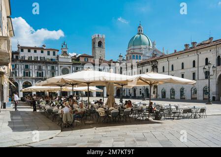 Italie piazza café, vue d'été des personnes se détendant aux tables de caffe dans l'ère Renaissance Piazza della Loggia dans le centre historique de Brescia, Italie Banque D'Images