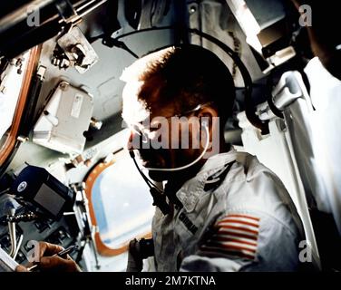 L'astronaute Walter Cunningham, pilote du module lunaire Apollo 7, écrit avec un stylo spatial tout en effectuant des tâches de vol le neuvième jour de la mission Apollo 7. Un magazine de film de 70 mm Hasselbald flotte juste au-dessus de la main droite de Cunningham dans l'environnement de gravité zéro de l'engin spatial. Pays : inconnu Banque D'Images