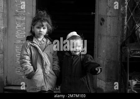 Une photo en noir et blanc de deux petites filles prises lors d'une promenade photo de rue dans la ville de Jérusalem, Israël Banque D'Images