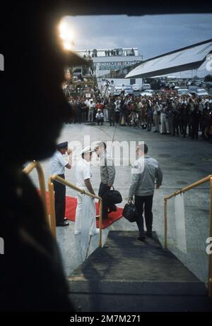 Vue de l'intérieur du C-141, deux ex-prisonniers de guerre sont accueillis à leur arrivée, après le vol de Hanoï, au nord du Vietnam, par (de gauche à droite) le Lgén William G. Moore Jr., commandant de la 13th Force aérienne et l'amiral Noel Gaylor, commandant du Commandement Pacifique. Objet opération/série: BASE POUR SOINS À DOMICILE: Clark Air base État: Luzon pays: Philippines (PHL) Banque D'Images