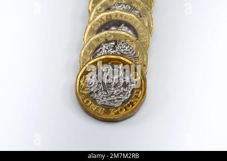 Vue rapprochée d'une rangée de pièces de monnaie britannique One Pound isolées sur un fond blanc Uni. Copier l'espace. Banque D'Images