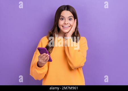 Photo de l'étonnant excitée utilisateur mignon dame impressionné bas prix vente moderne appareil gadgets isolés sur fond violet couleur Banque D'Images