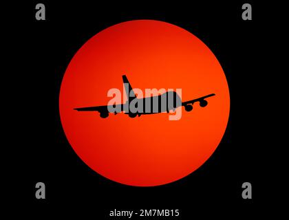 silhouette noire de l'avion contre le soleil orange dans le ciel noir. Banque D'Images