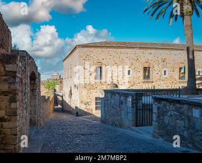 Una calle peatonal empedrada y en cuesta en el barrio antiguo de Cáceres, España Banque D'Images