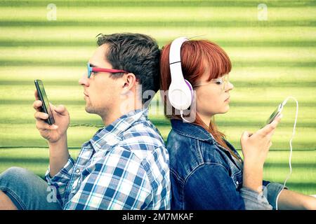 Hipster couple dans le moment de désintérêt avec les téléphones mobiles - concept de l'apathie tristesse et l'isolement en utilisant les nouvelles technologies - Boyfriend et petite amie wi Banque D'Images