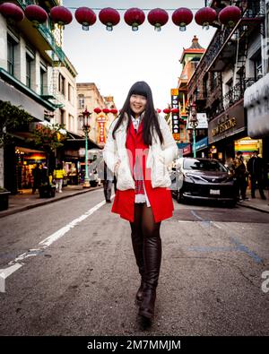 Jeune femme marchant dans la rue à Chinatown San Francisco Banque D'Images