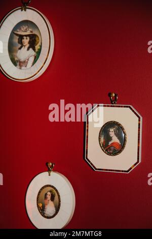 Mur rouge avec 3 portraits de femmes encadrés Banque D'Images