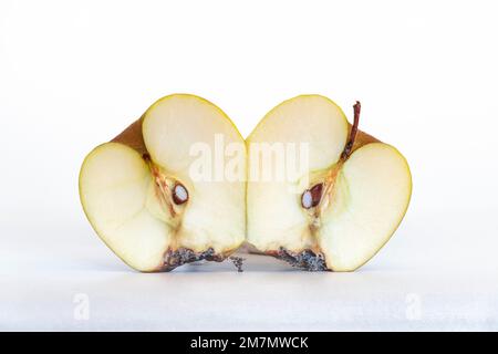 Pomme pourrie, déshydratée et pourrie, une pomme coupée en deux, deux moitiés de pomme, isolée sur fond blanc Banque D'Images