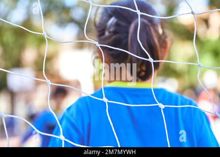 filet de but de football non reconnaissable sur un match de football pour enfants avec gardien de but non reconnaissable sur le fond Banque D'Images